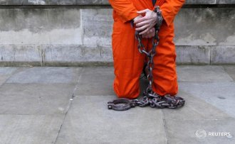 A demonstrator dressed as a prisoner, protests up against the U.S. prison