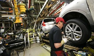 an employee produces a car or truck at Nissan’s construction plant